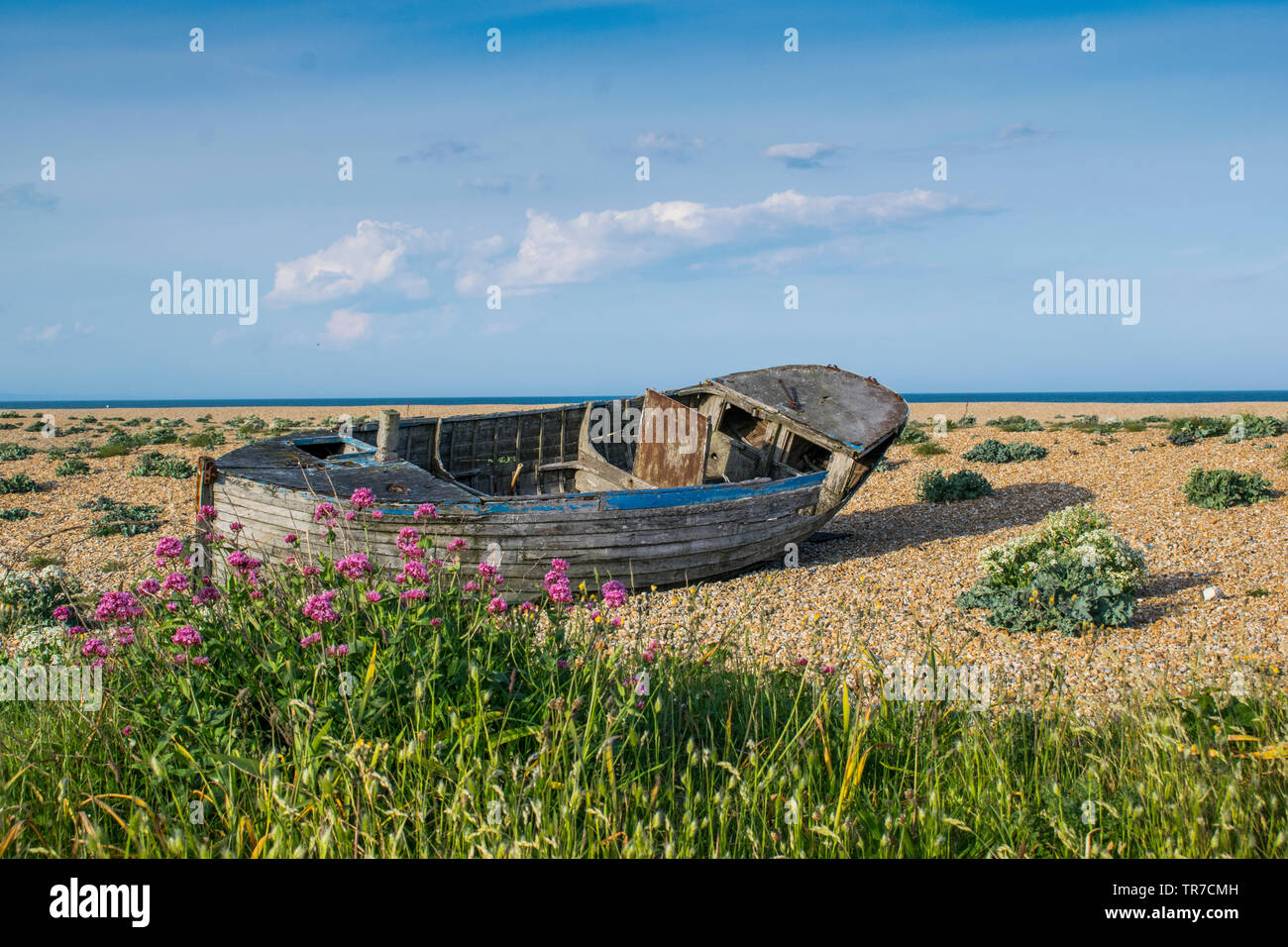 Abandoned wooden fishing boat on a pebble beach Stock Photo