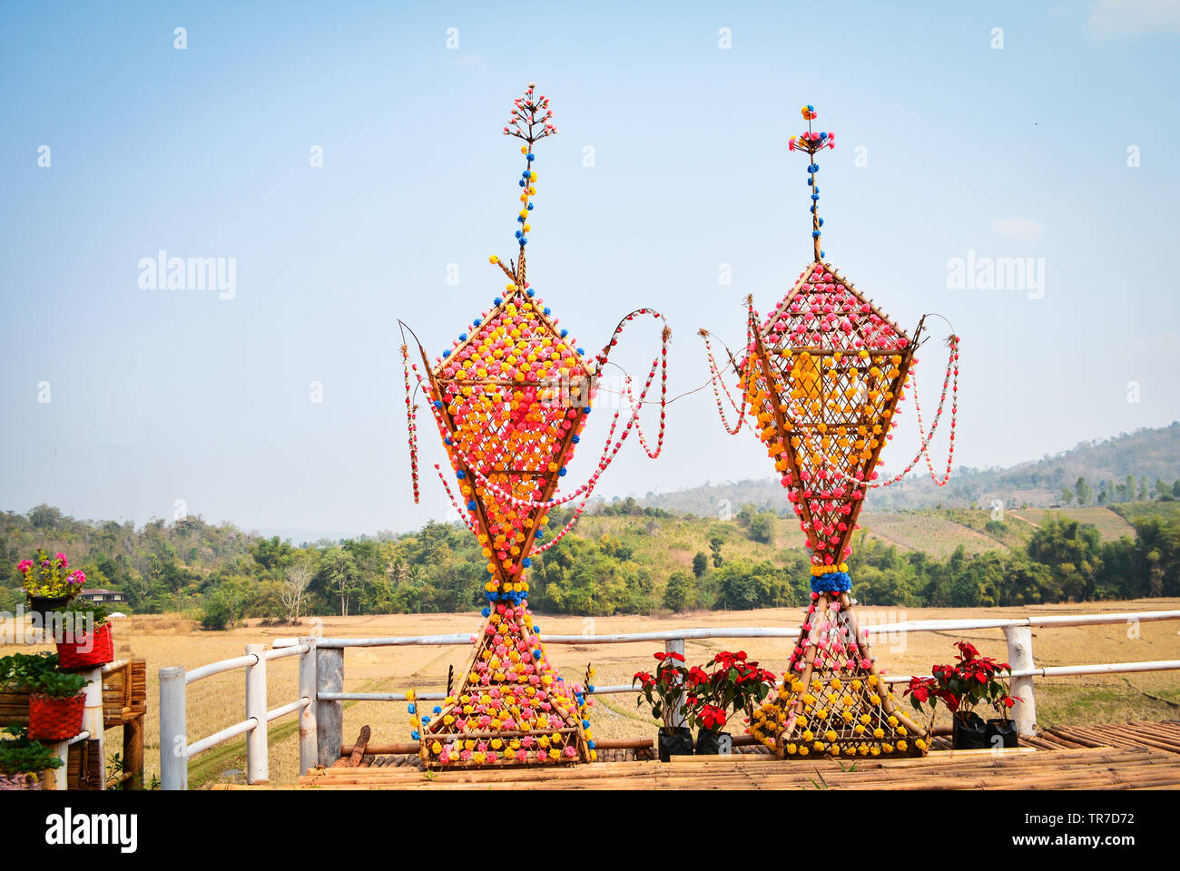Colorful of flower decorate on bamboo tower shape pyramit with flowers show on balcony and view hill background for buddhist festival at Na Haeo Loei Stock Photo