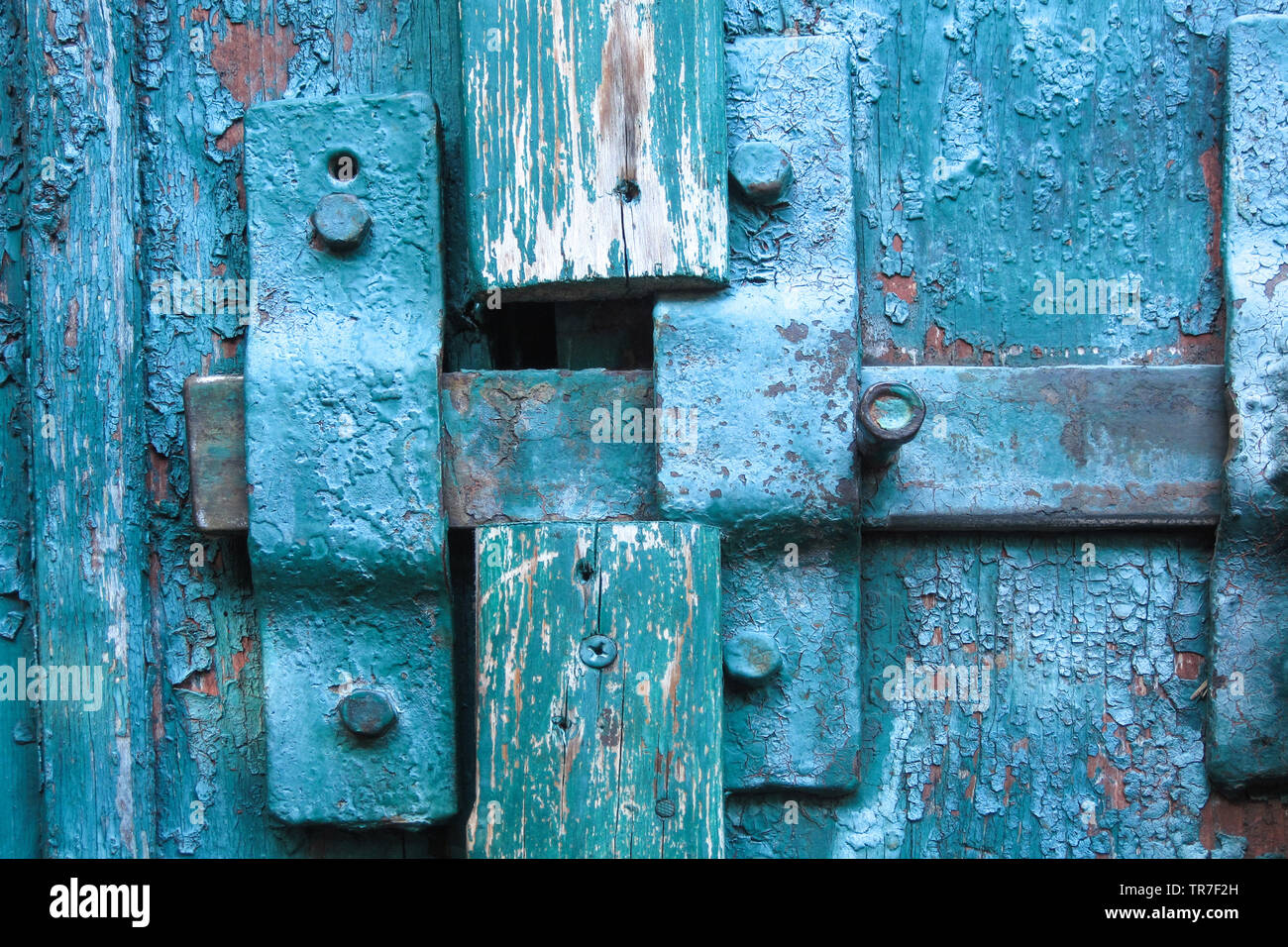 Vintage closed latch on weathered scratched wooden door. Concept of security and privacy protection. Textured grunge background Stock Photo