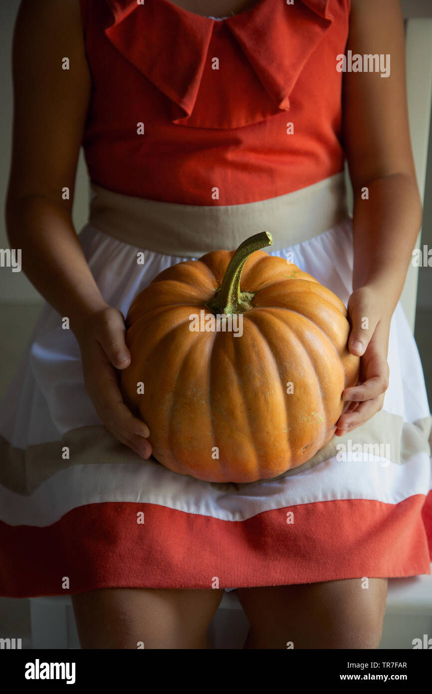 Girl holding a big pumpkin Stock Photo - Alamy