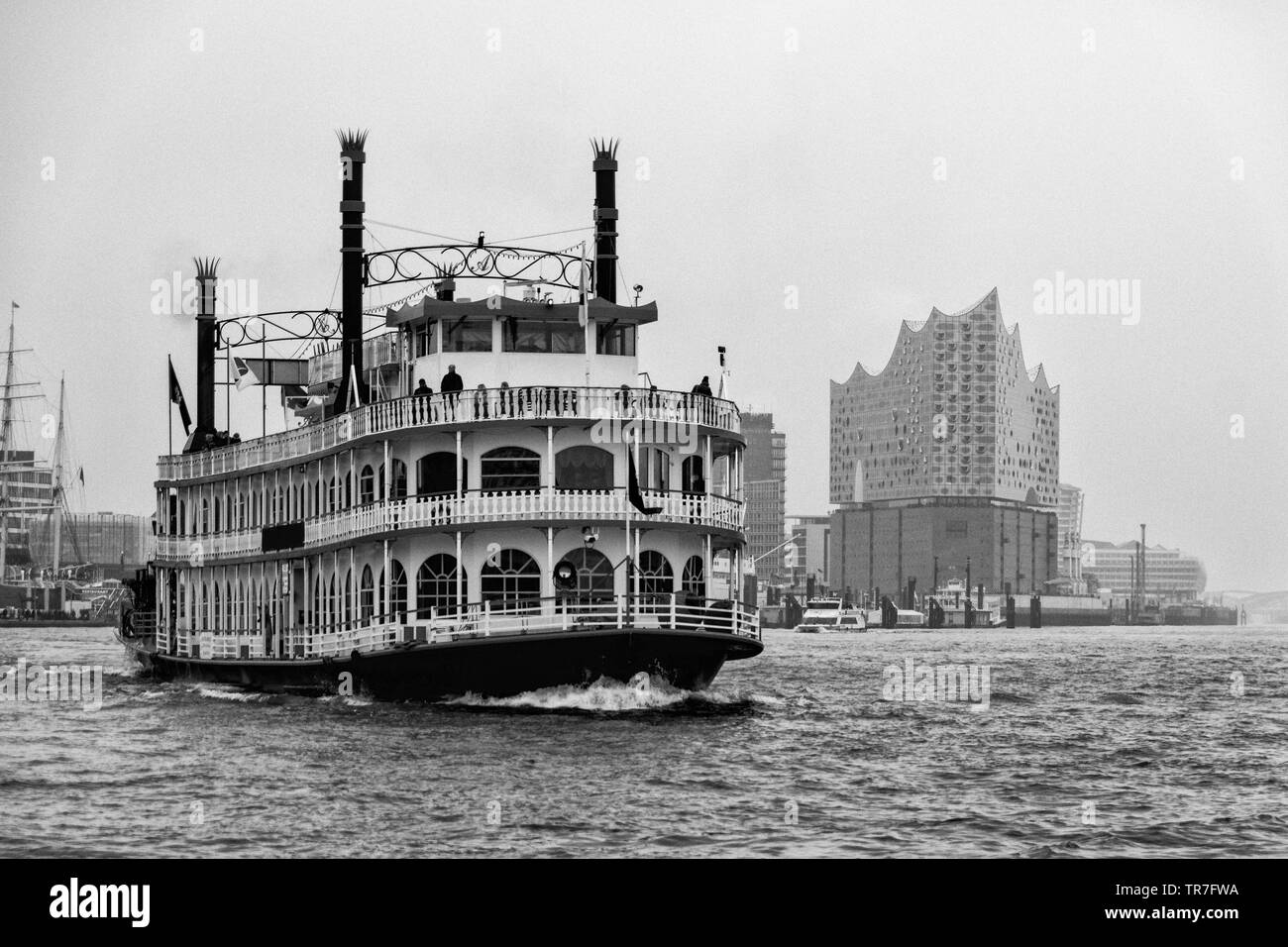 black and white Portrait of a paddle wheel steamer in Hamburg with Elbphilharmonie in the background Stock Photo