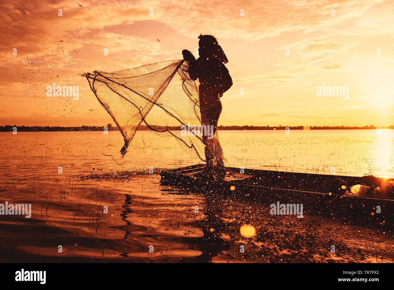 https://c8.alamy.com/comp/TR7FX3/asia-fisherman-using-net-fishing-on-wooden-boat-casting-net-sunset-or-sunrise-in-the-river-silhouette-fisherman-stand-on-boat-life-person-at-country-TR7FX3.jpg