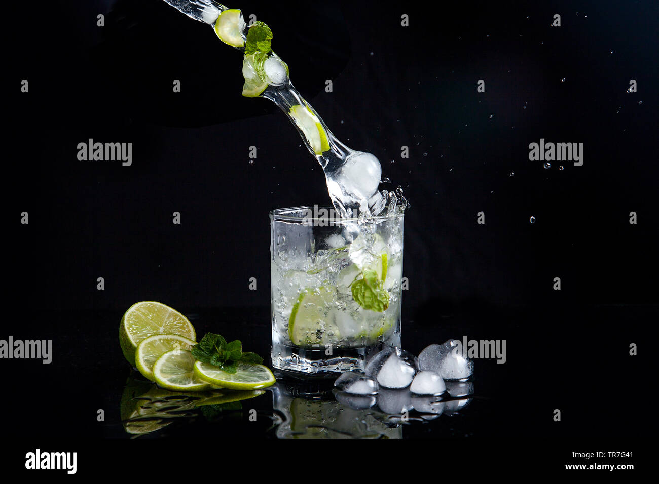 Mojito summer beach refreshing tropical cocktail in glass with splash soda water, lime juice