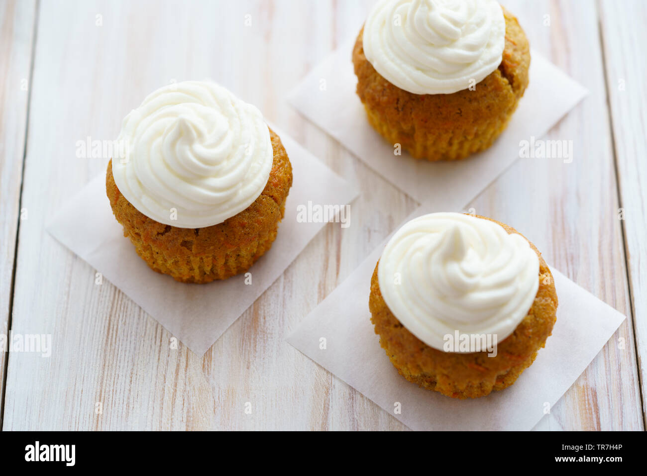 Carrot cupcakes with vanilla frosting. White wooden table, high resolution Stock Photo