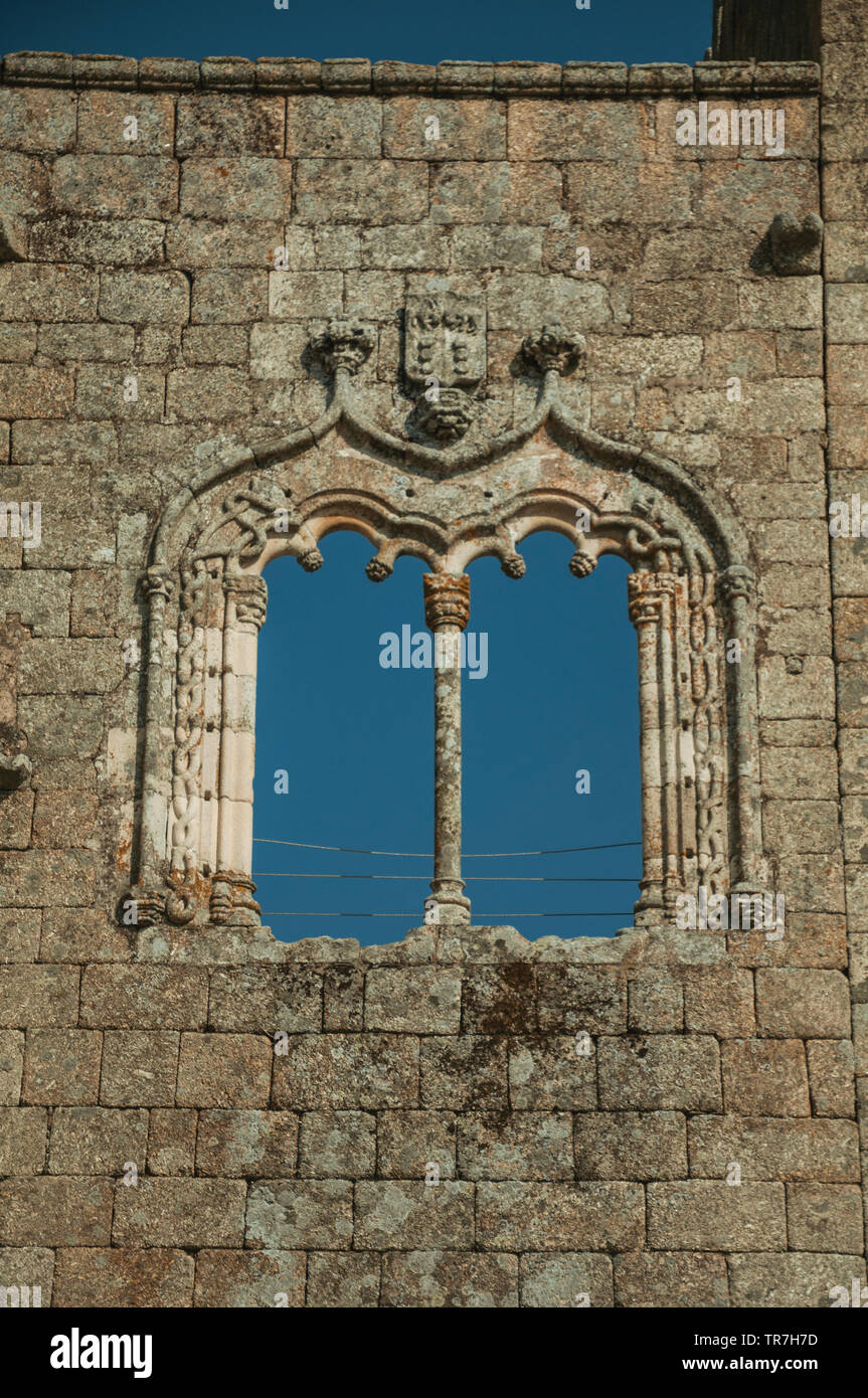 Decorated window in gothic style on a wall made of stone at the medieval Belmonte Castle. Birthplace of the discoverer Pedro Cabral in Portugal. Stock Photo