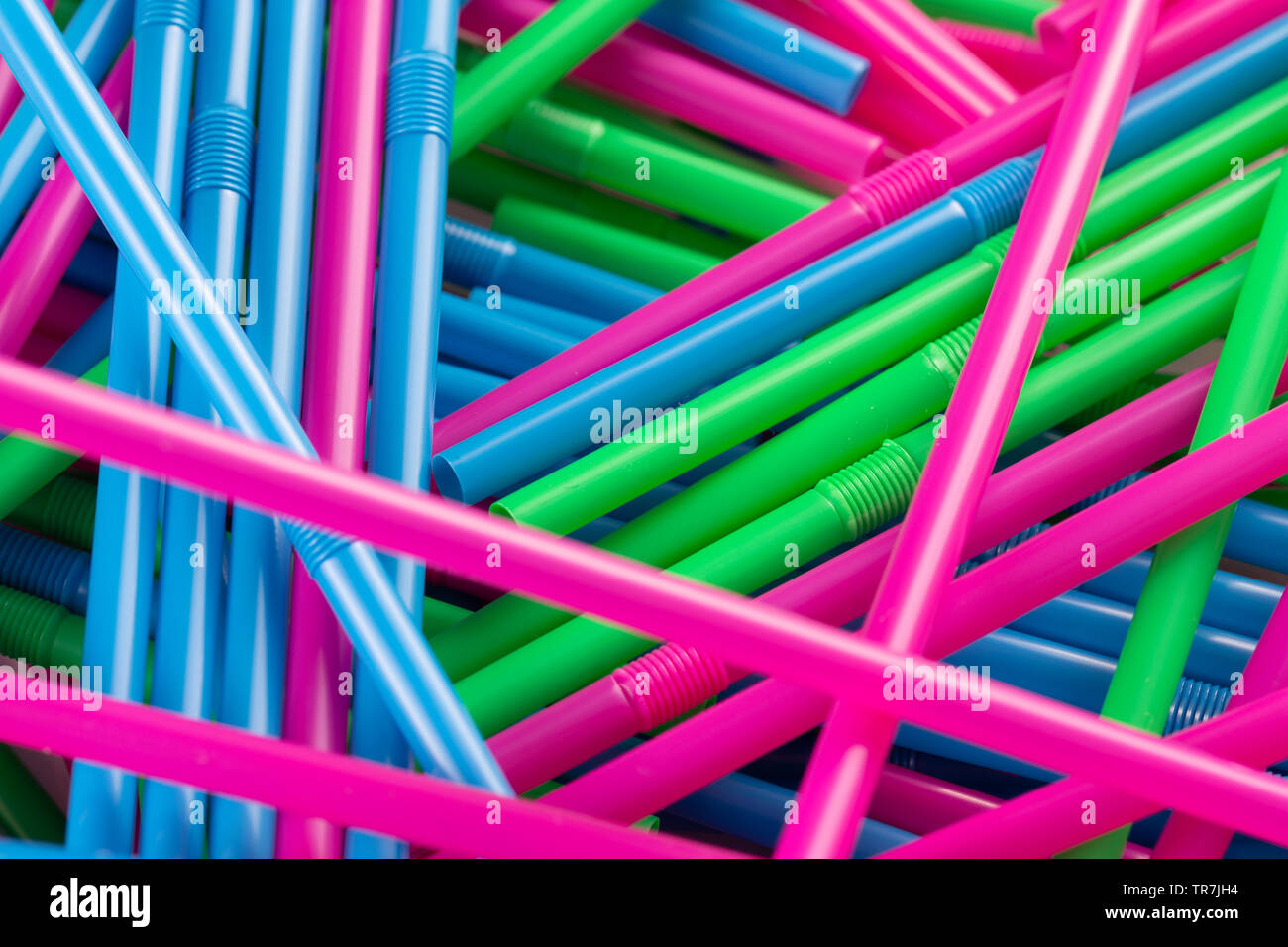Pile of multicoloured plastic drink straws ideal for a background. Shows concept of plastic waste and the ban on plastic drinking straws Stock Photo