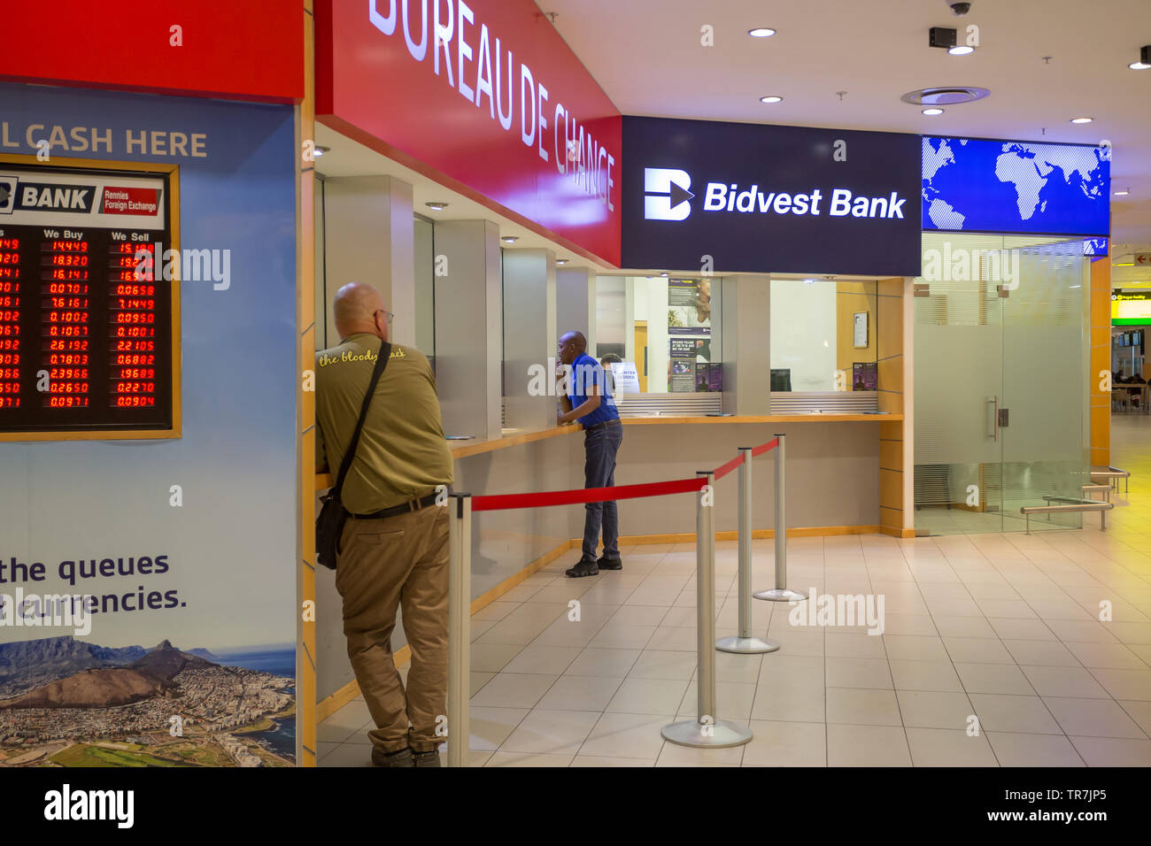 Bureau de change foreign exchange and Bidvest Bank kiosks with tourists or people at the counters in Cape Town International Airport terminal building Stock Photo