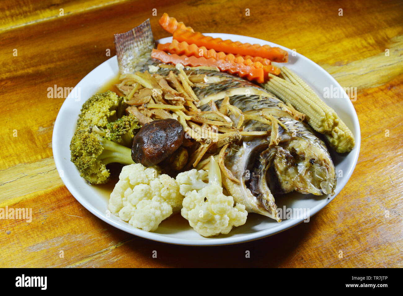 steamed mango fish with slice ginger and vegetable in soy sauce on dish ...