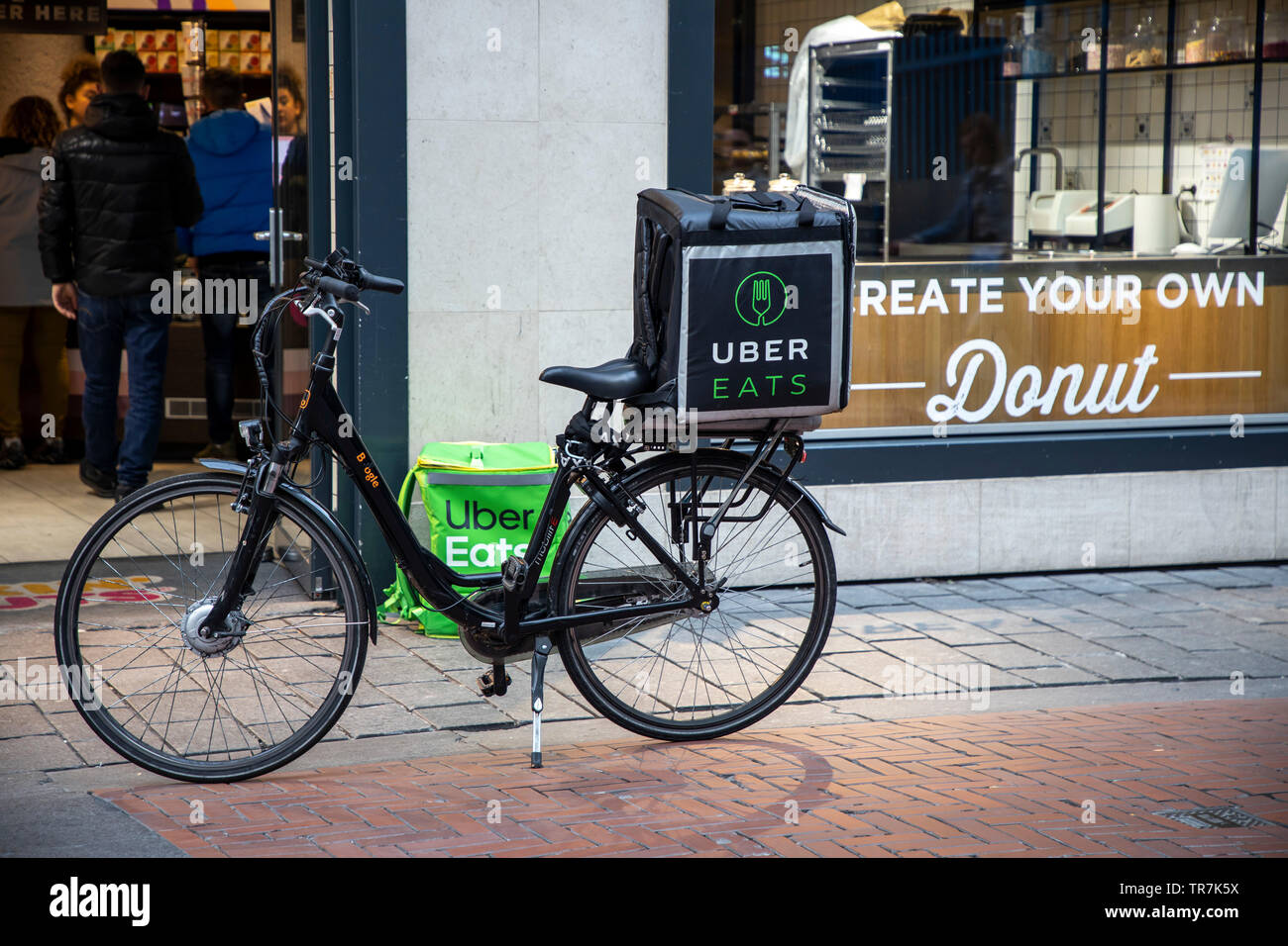 Noordoosten kathedraal genade Amsterdam, Netherlands, couriers of the food online delivery service Uber  Eats, bicycle supplier and delivery courier on foot Stock Photo - Alamy