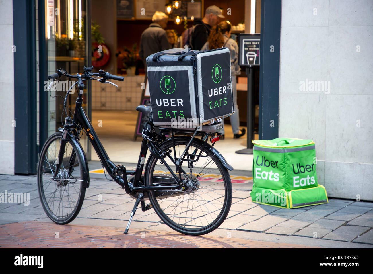 Noordoosten kathedraal genade Amsterdam, Netherlands, couriers of the food online delivery service Uber  Eats, bicycle supplier and delivery courier on foot Stock Photo - Alamy