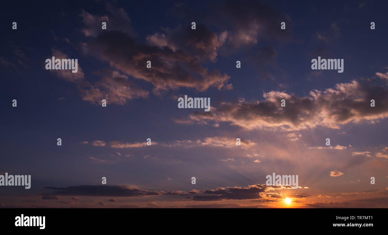 Dramatic sunset sky with orange colored clouds and sun Stock Photo - Alamy