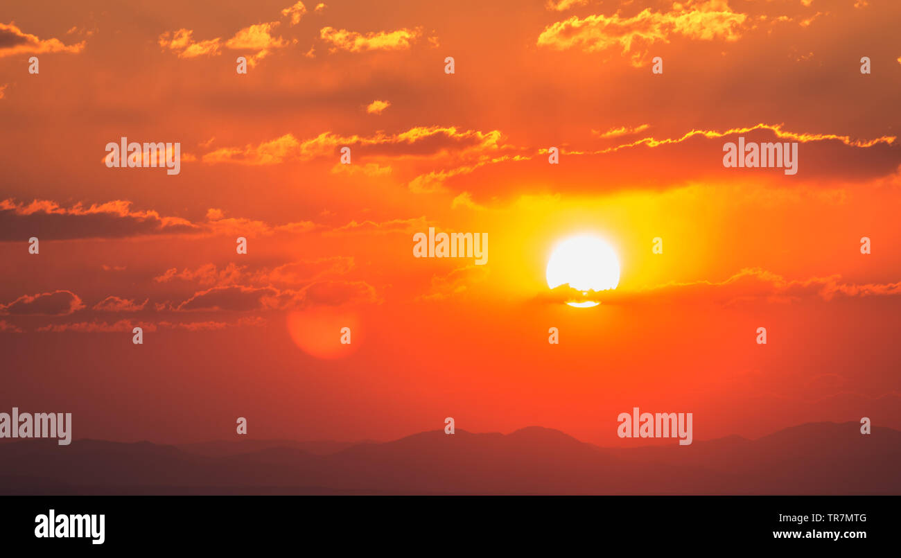Dramatic sunset sky with orange colored clouds and sun Stock Photo - Alamy