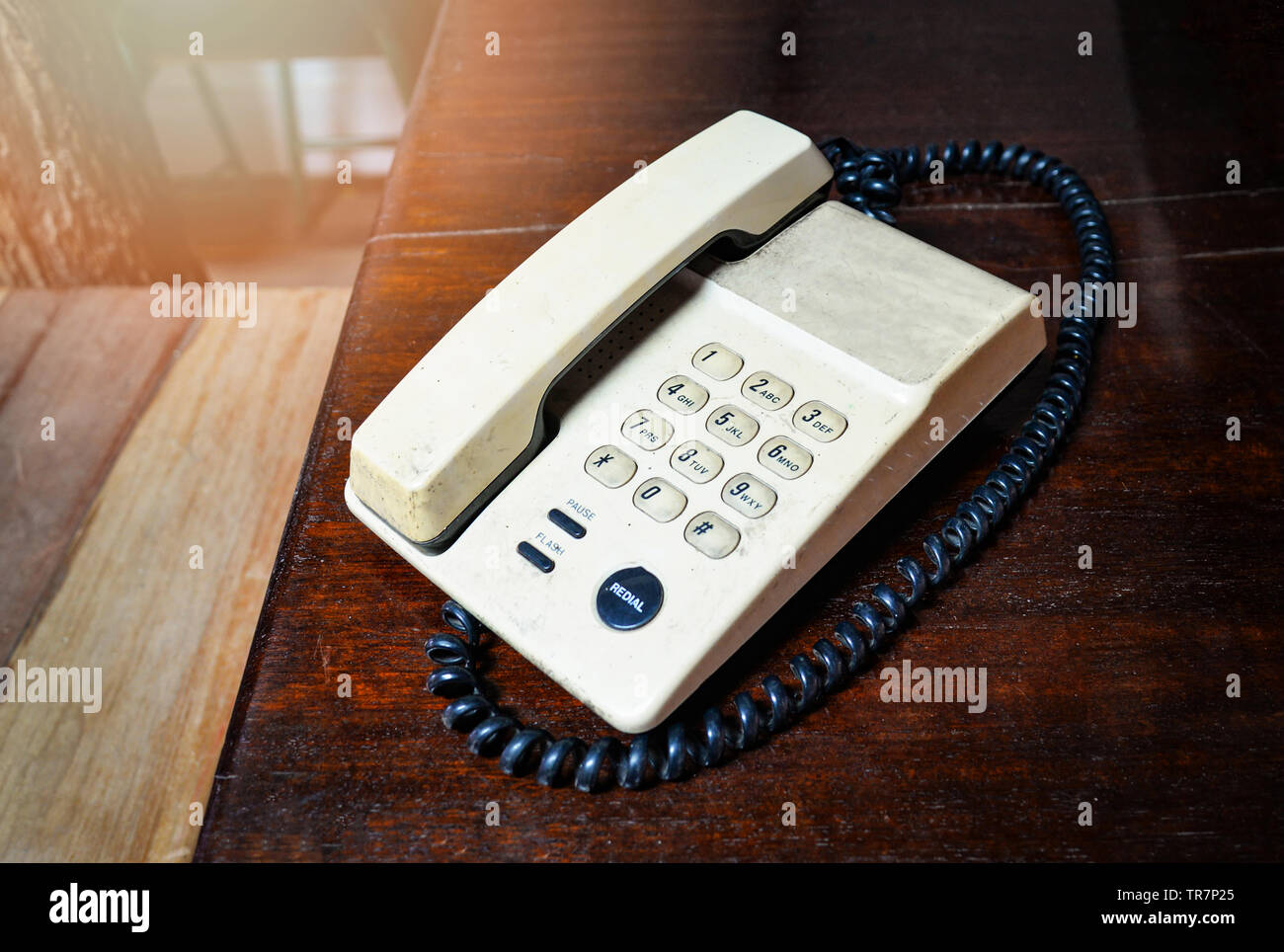 Retro telephone old on wooden table in office ancient tone style / Home phone dial up landline