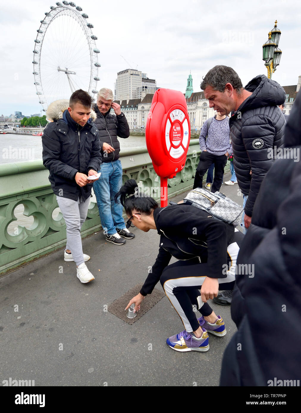 London, England, UK. Illegal Cup and Ball / 3 Cups Trick on Westminster Bridge, trying to con money from passing tourists Stock Photo