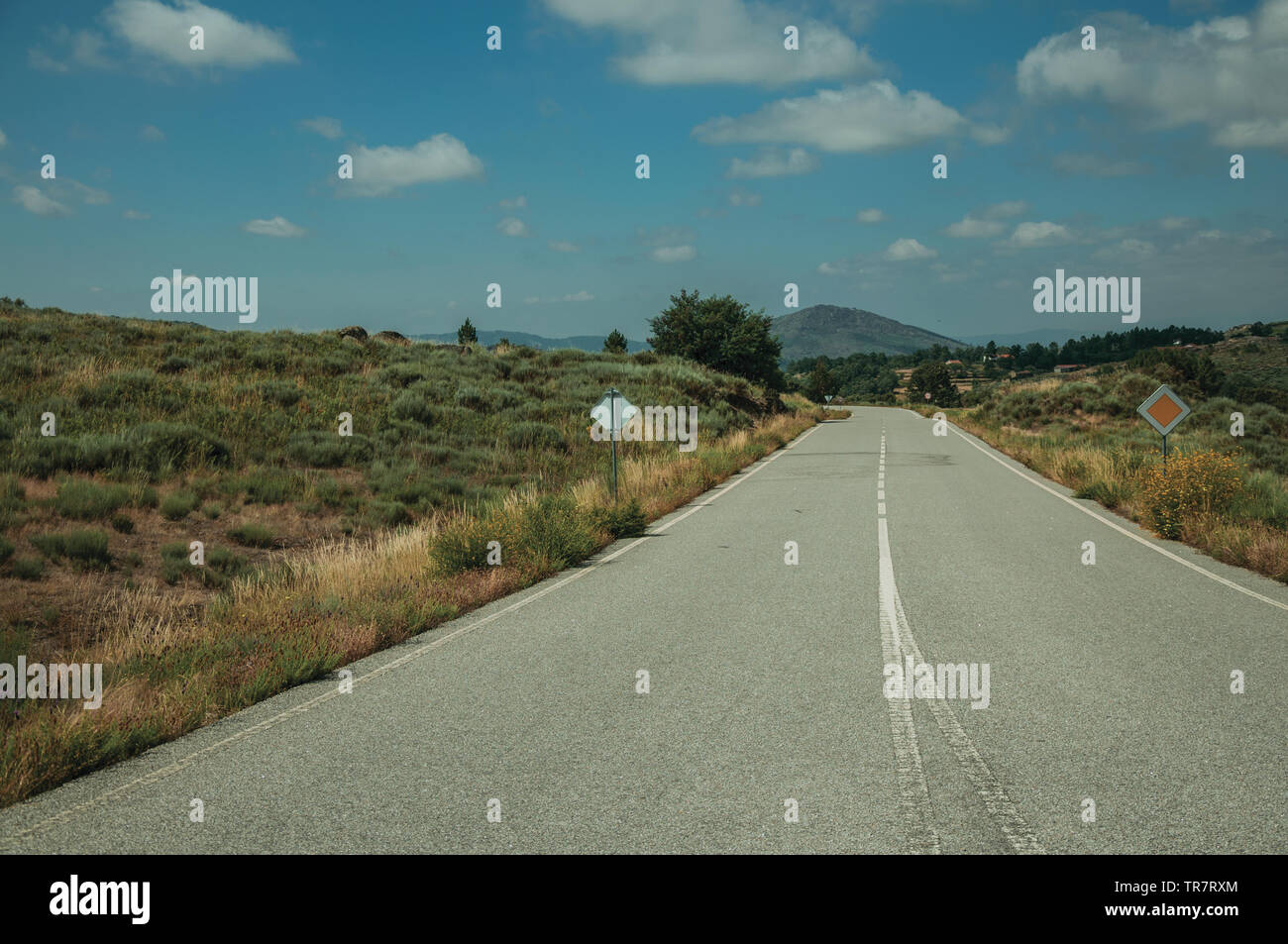 Deserted road on rural landscape with fields covered by rocks and bushes near Sortelha. An astonishing and well preserved medieval hamlet in Portugal. Stock Photo