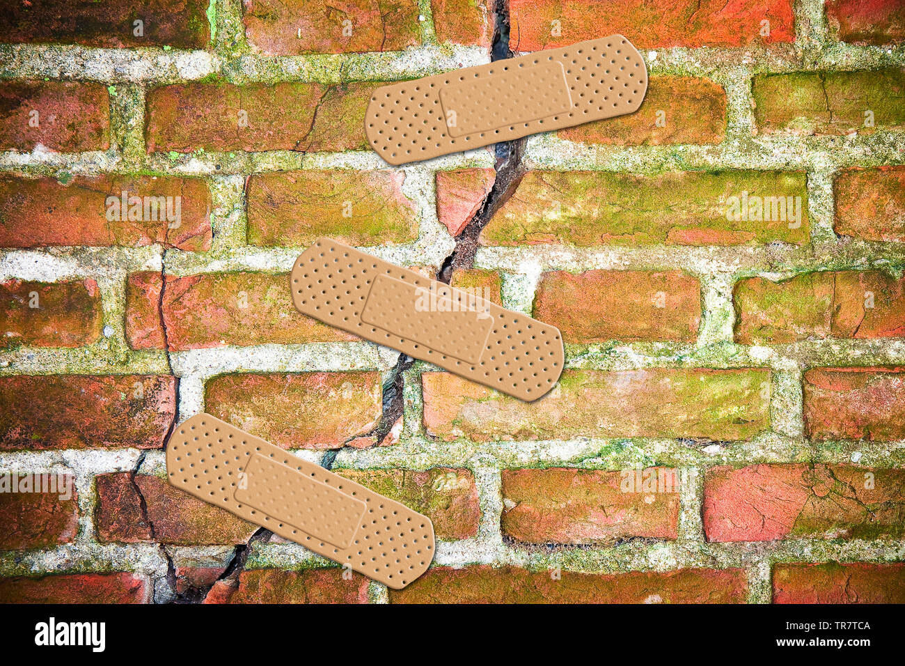 Renovation of an old cracked brick wall - concept image with bandaid patch Stock Photo