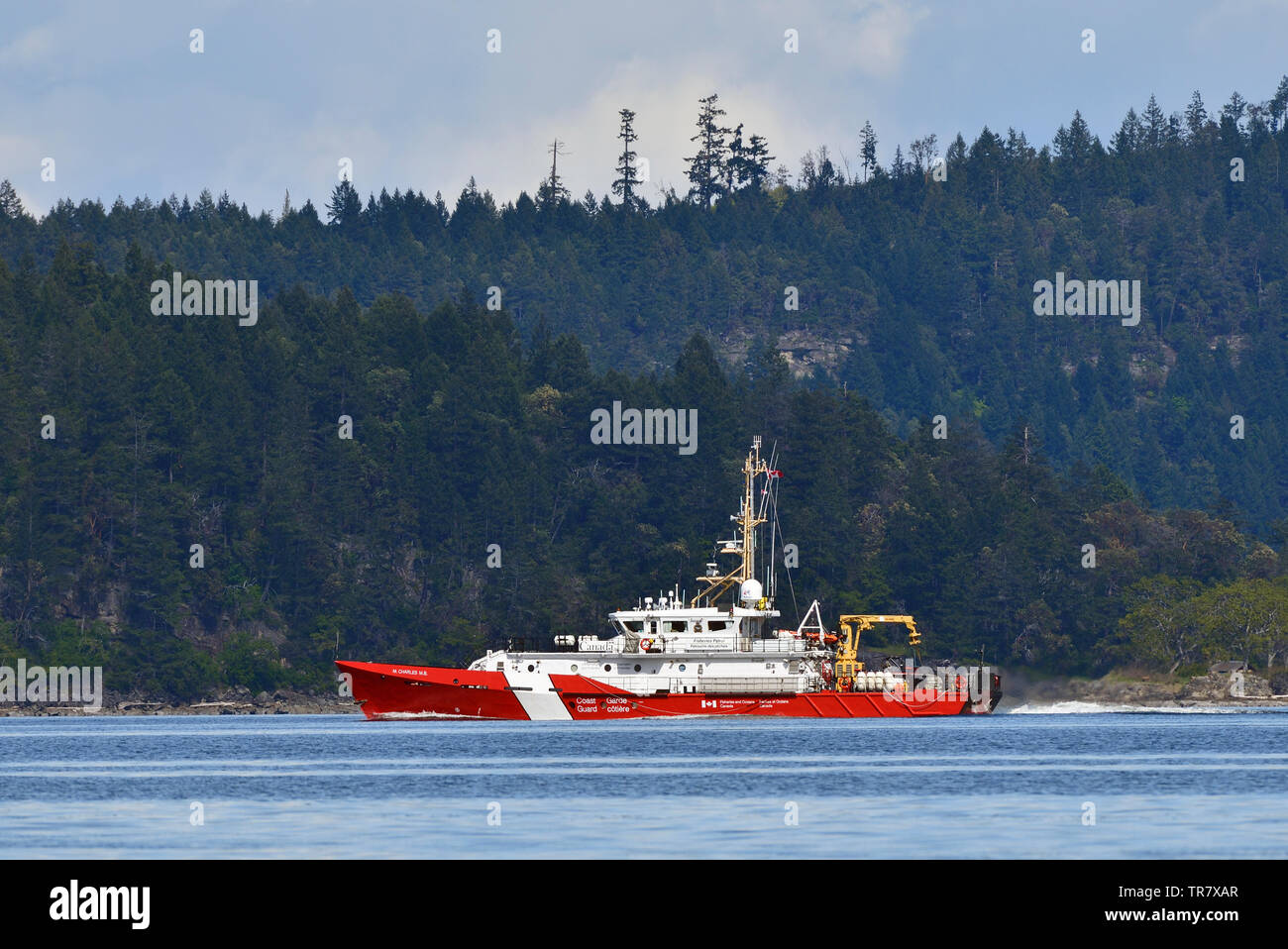 A Canadian Coast Guard fisheries patrol vessel traveling on the waters of The Strait of Georgia near Vancouver Island British Columbia Canada. Stock Photo