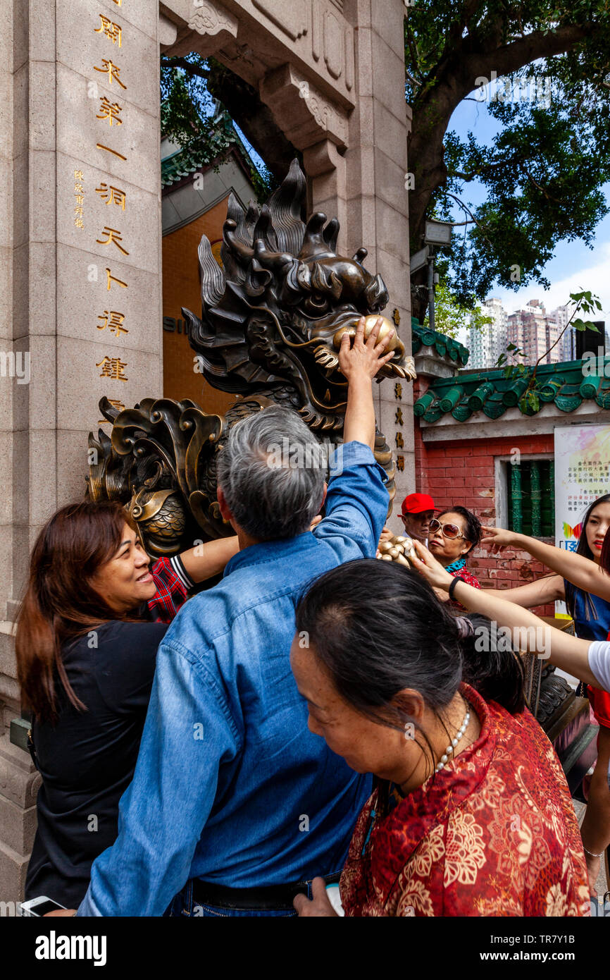 Chinese Tourists Rub The Dragon Statue For Good Luck At The Entrance To