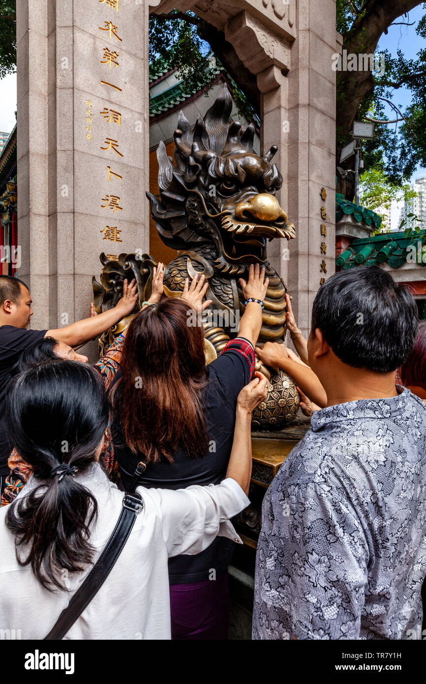 Chinese Tourists Rub The Dragon Statue For Good Luck At The Entrance To