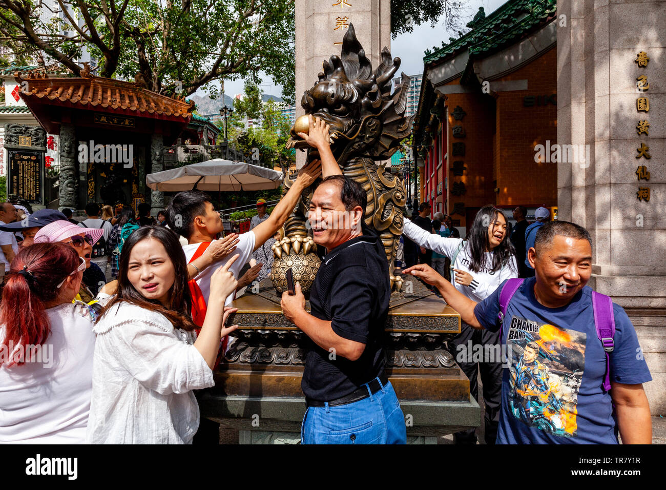 Chinese Tourists Rub The Dragon Statue For Good Luck At The Entrance To