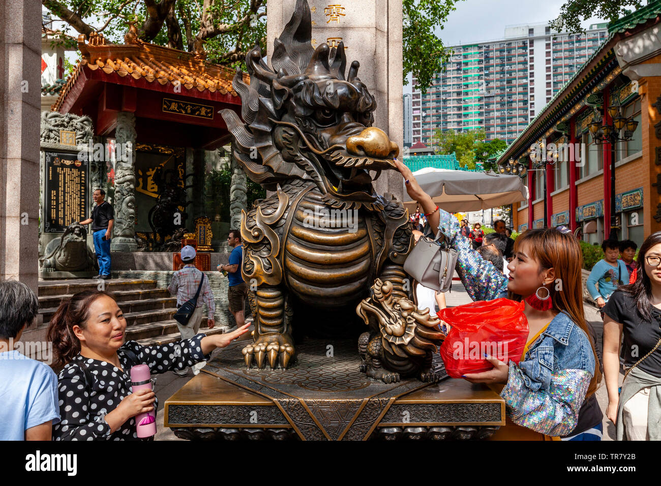Chinese Tourists Rub The Dragon Statue For Good Luck At The Entrance To