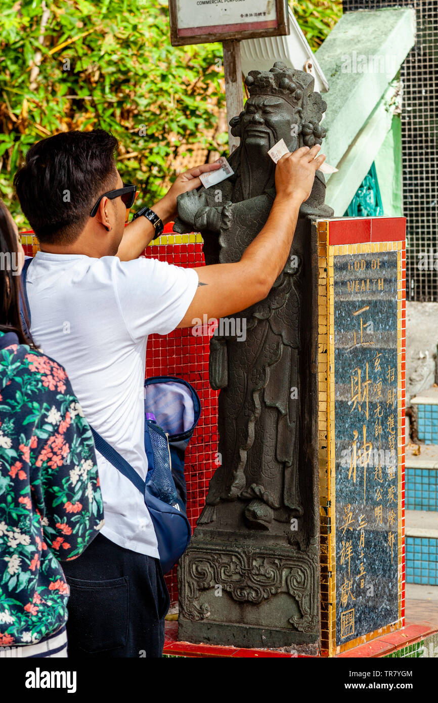 Chinese Tourists Rub The God Of Wealth Statue To Bring Good Fortune