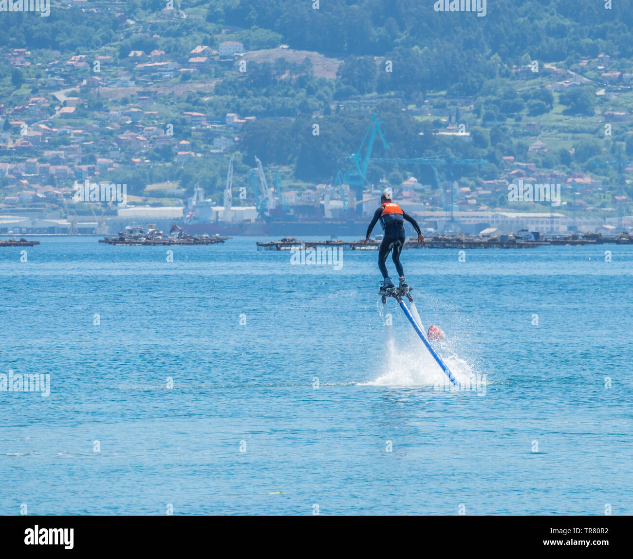 young man enjoys practicing flyboard in the afternoon on the ria de Vigo in Spain Stock Photo