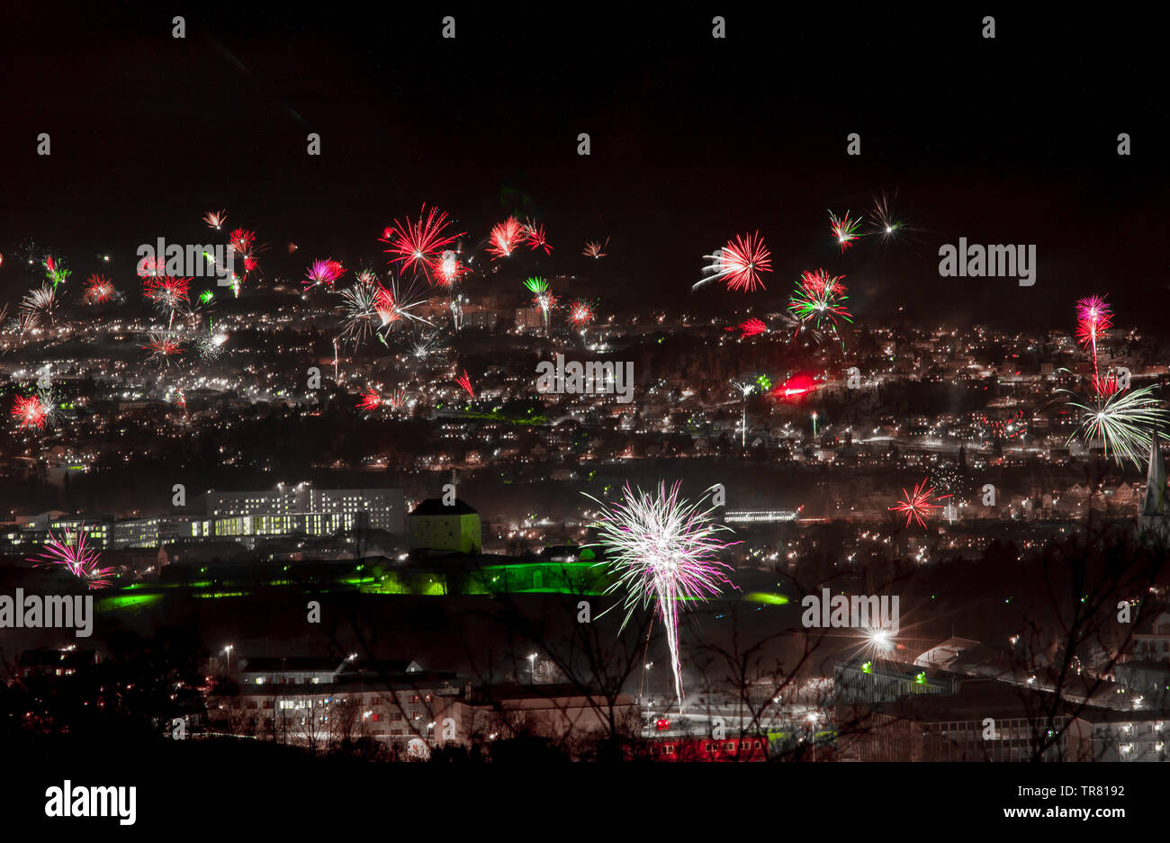 New year's eve fireworks over a dark town. Stock Photo