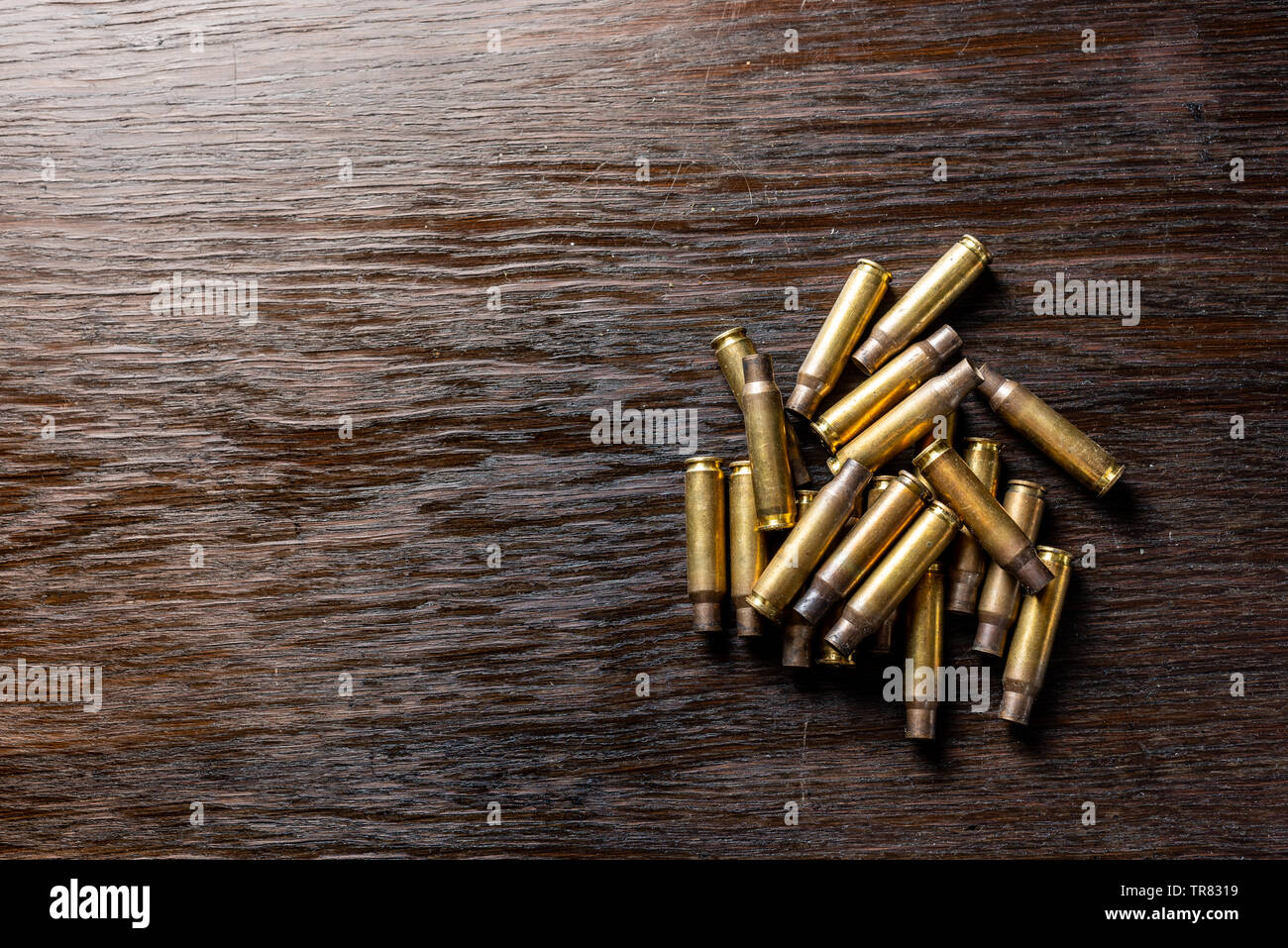 Empty bullet casings on a dark, wooden table Stock Photo - Alamy