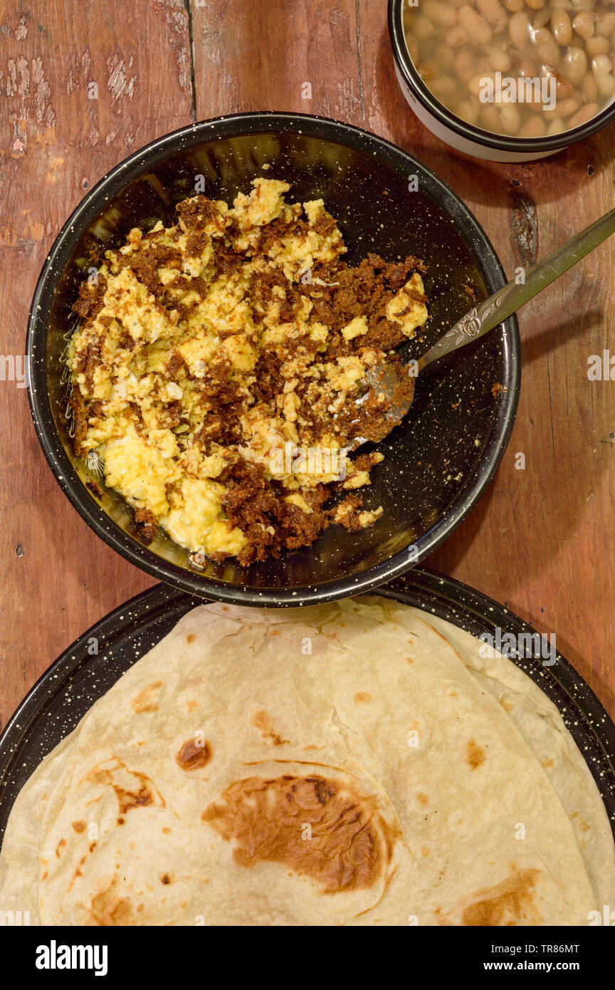 Mexican breakfast, machaca from Sonora with eggs, beans and flour tortillas. For restaurant, food blog, Mexican food. Copy space. Stock Photo
