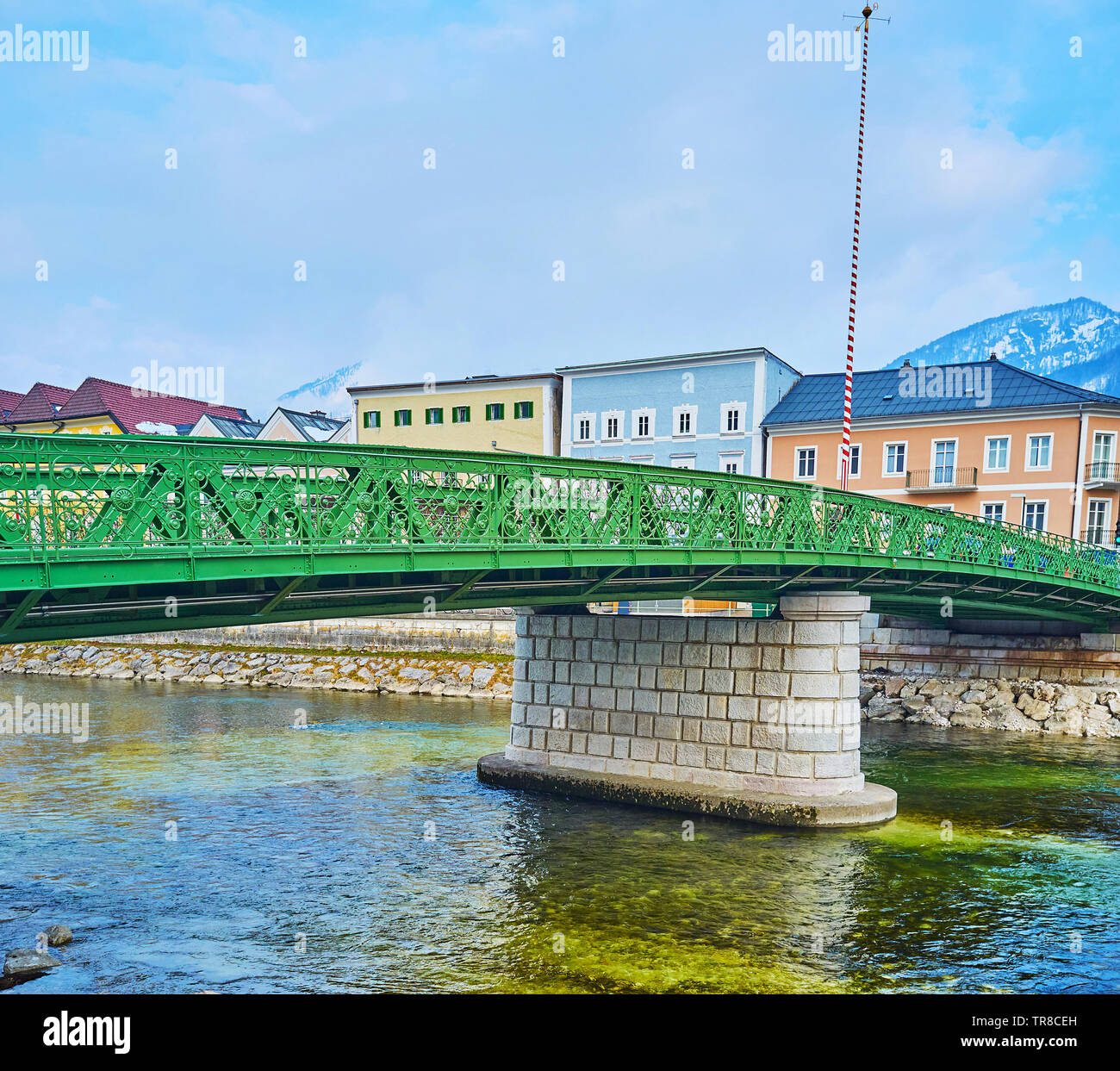 The green lacelike bridge of Kaiserin Elizabeth connects the banks of Traun river and central neighborhoods of Bad Ischl, Salzkammergut, Austria. Stock Photo