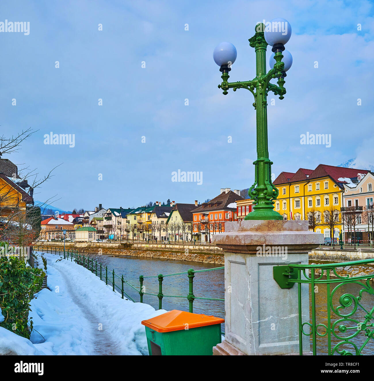 The narrow snowy footpath along the Oscar-Straus-Kai embankment with a view on vintage streetlight of Elizabethbrucke and colorful townhouses on Espla Stock Photo