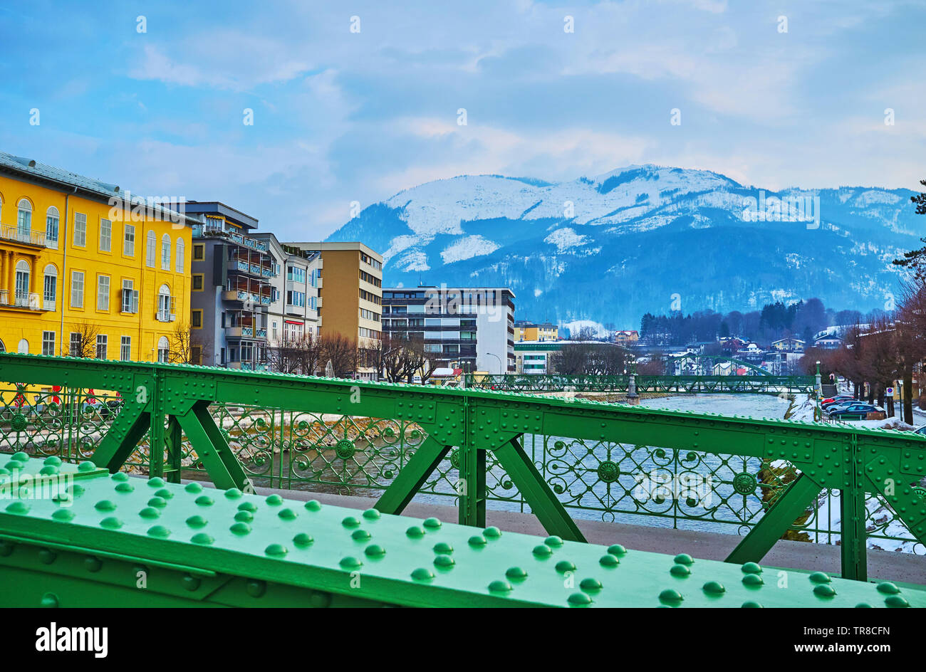 Kaiserin Elizabeth bridge (Elizabethbrucke) overlooks old town with its edifices, parks, Traun river and snowy Alps on the background, Bad Ischl, Salz Stock Photo