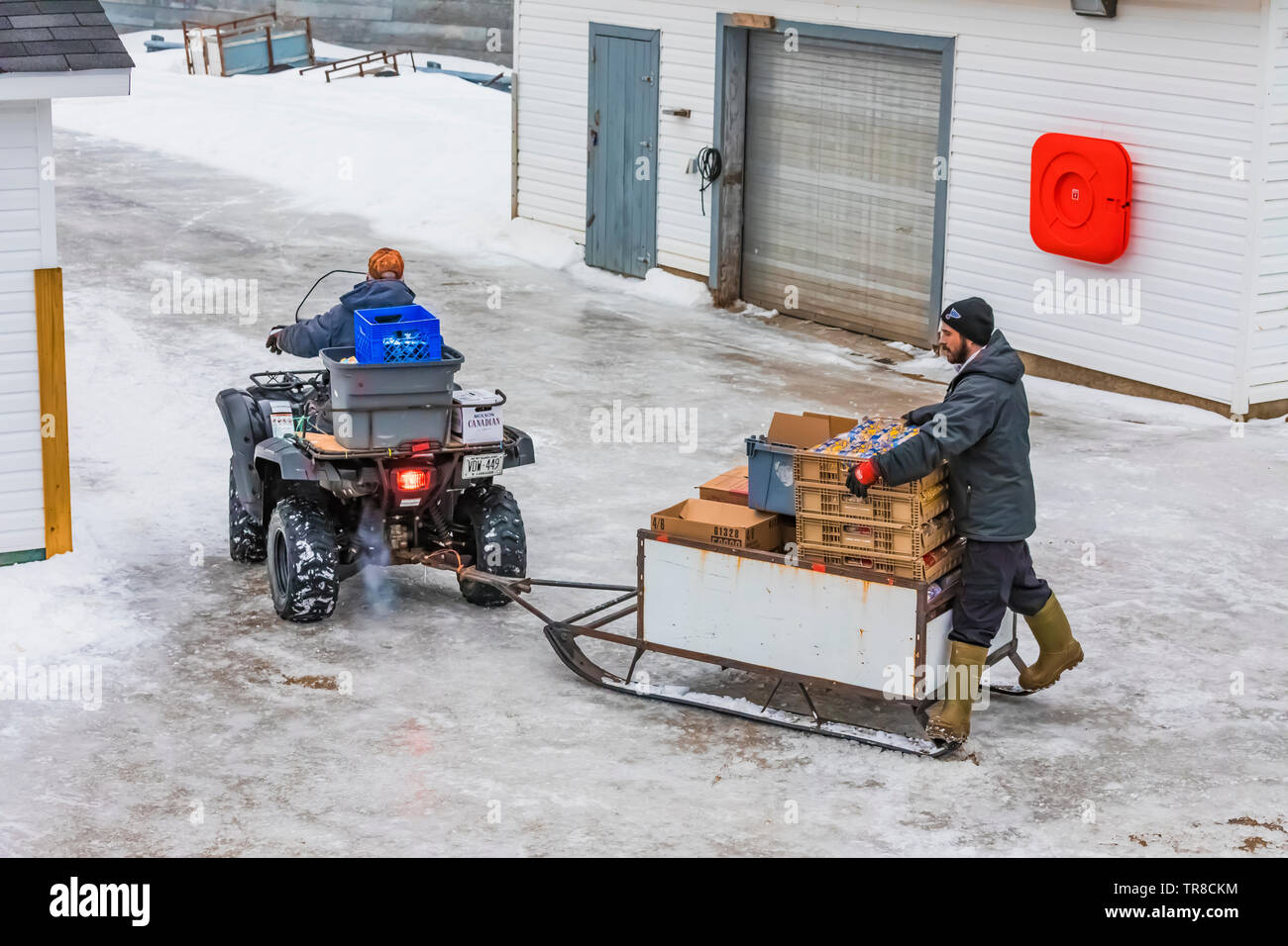 Transporting cargo from dock to store by ATV at the outport of Grey River, viewed from the ferry Marine Voyager, Newfoundland, Canada [No property or Stock Photo