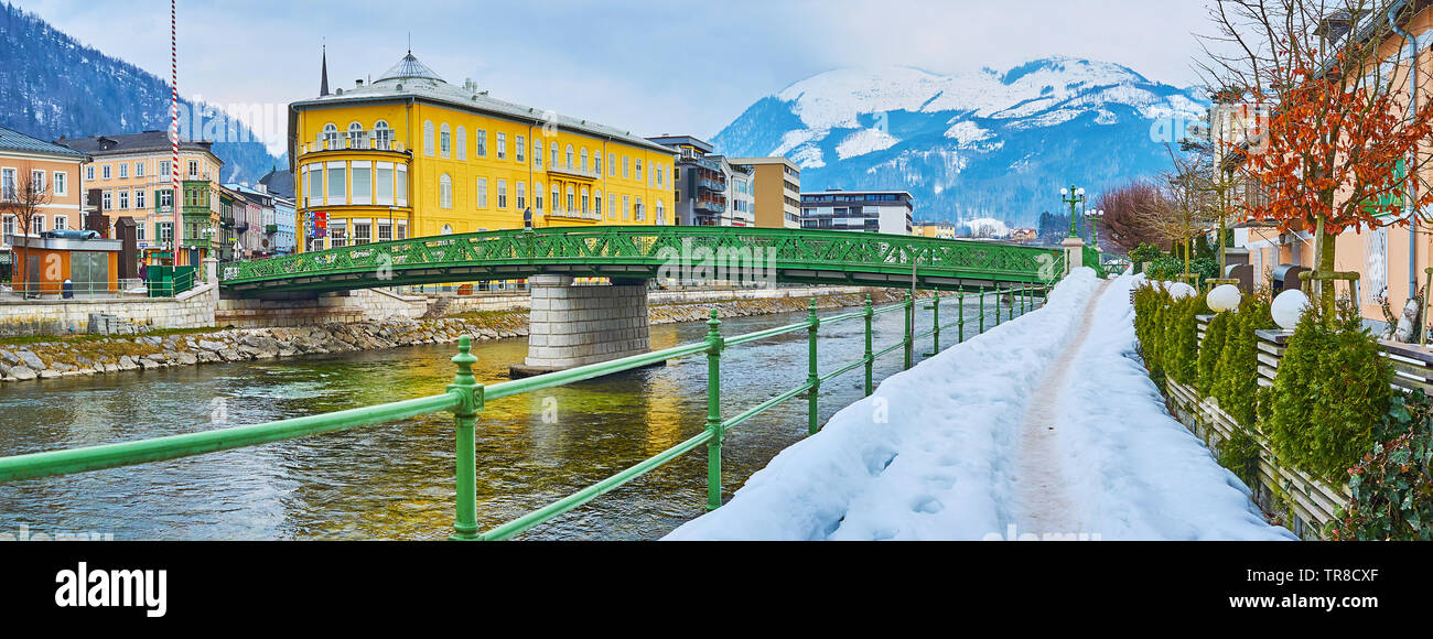 Panorama of snowy embankment of Traun river, bright green bridge of Kaiserin Elisabeth (Elizabethbrucke), colorful housing and Alps on background, Bad Stock Photo