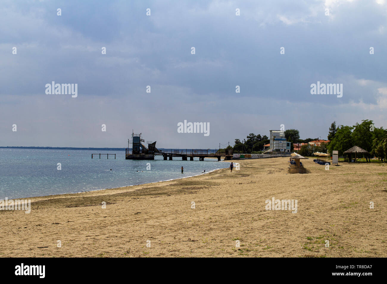 The beach and small jetty at the small seaside tourist resort of Gerakini.Halkidiki, Greece. Stock Photo