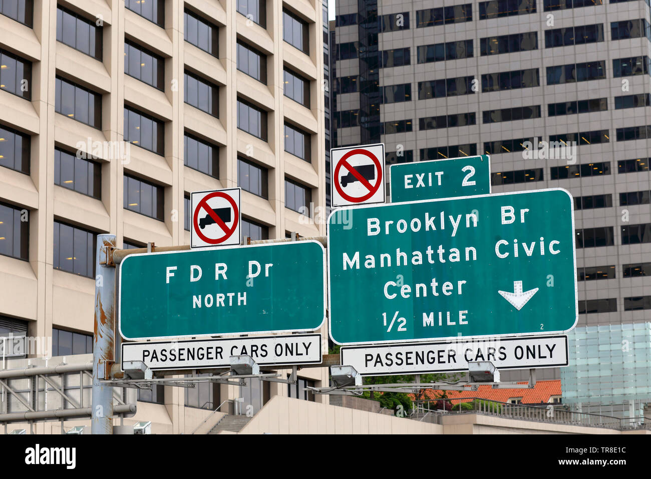 Highway signs on the FDR Drive, New York pointing drivers toward the Brooklyn Bridge, and to the Civic Center. Signs set against a backdrop of Manhatt Stock Photo