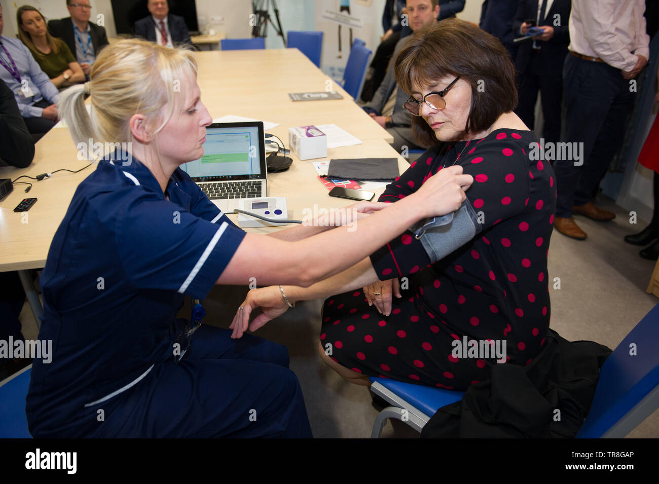 East Kilbride, UK. 30 May 2019.EMBARGO UNTIL 31 MAY AT 00:01 Pictured: (left-right) Laura MacKinnon; Jeane Freeman. New technology that allows patients to monitor their blood pressure at home will be rolled out across Scotland.  The Scale-Up BP initiative reduces the need for GP consultations, and can help to deliver more accurate readings.  Patients are shown how to measure their own blood pressure and text the results to an app called Florence, or Flo. Colin Fisher/Alamy Live News Stock Photo