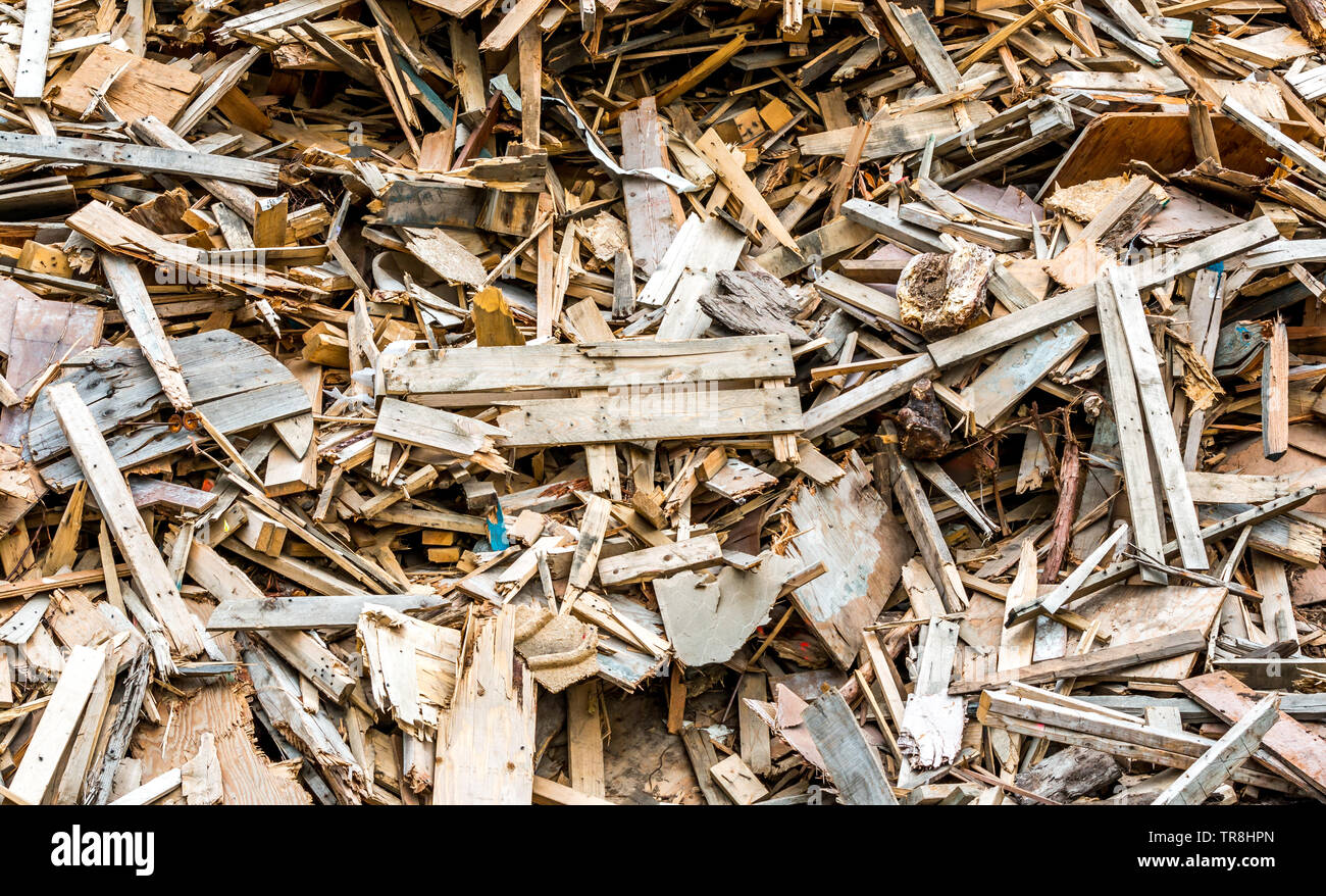 Wood waste and old pallets are piled up to be recycled. Stock Photo