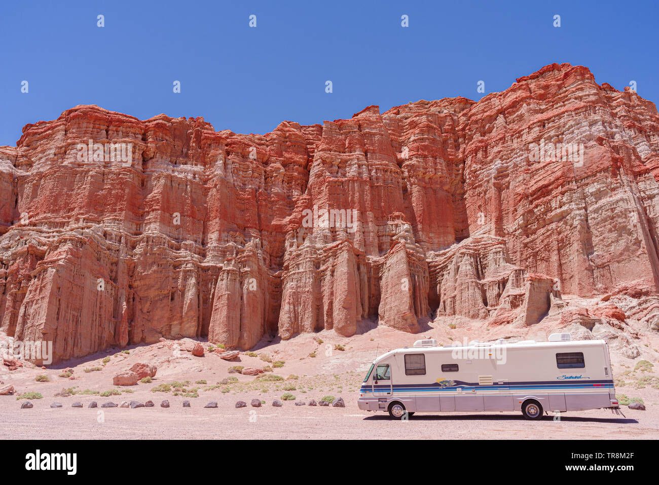 Recreational vehicle shown by the Red Cliffs within Red Rock Canyon State Park  in Kern County in California. Stock Photo
