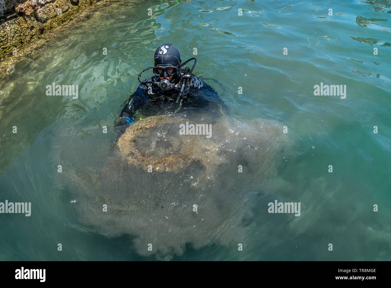 diver taking out a wheel from the bottom of the sea Mahon, Minorca May 22 2019 Stock Photo