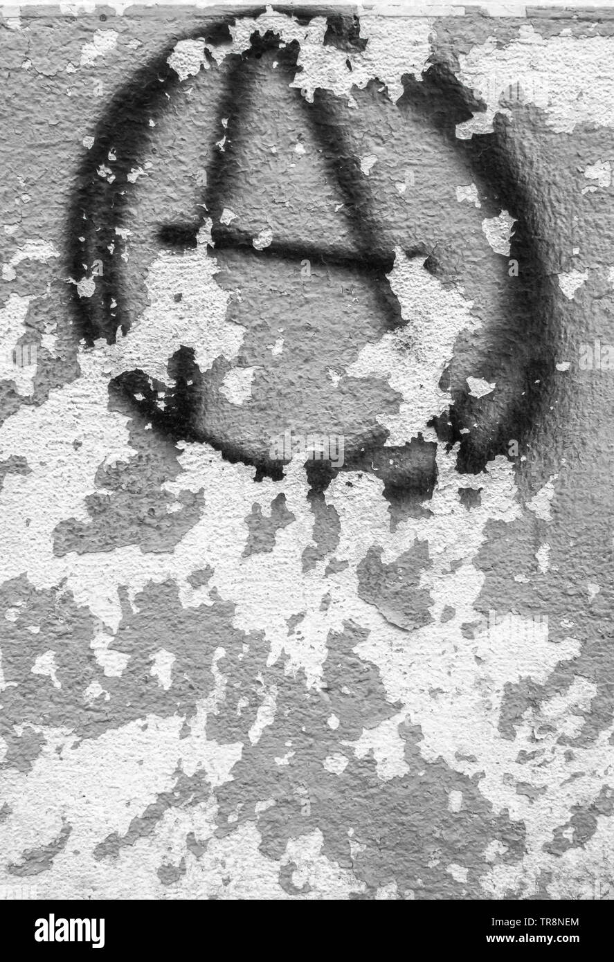 Symbol of anarchy painted on the peeling old wall. Ideal for textures ,backgrounds and concepts. Stock Photo