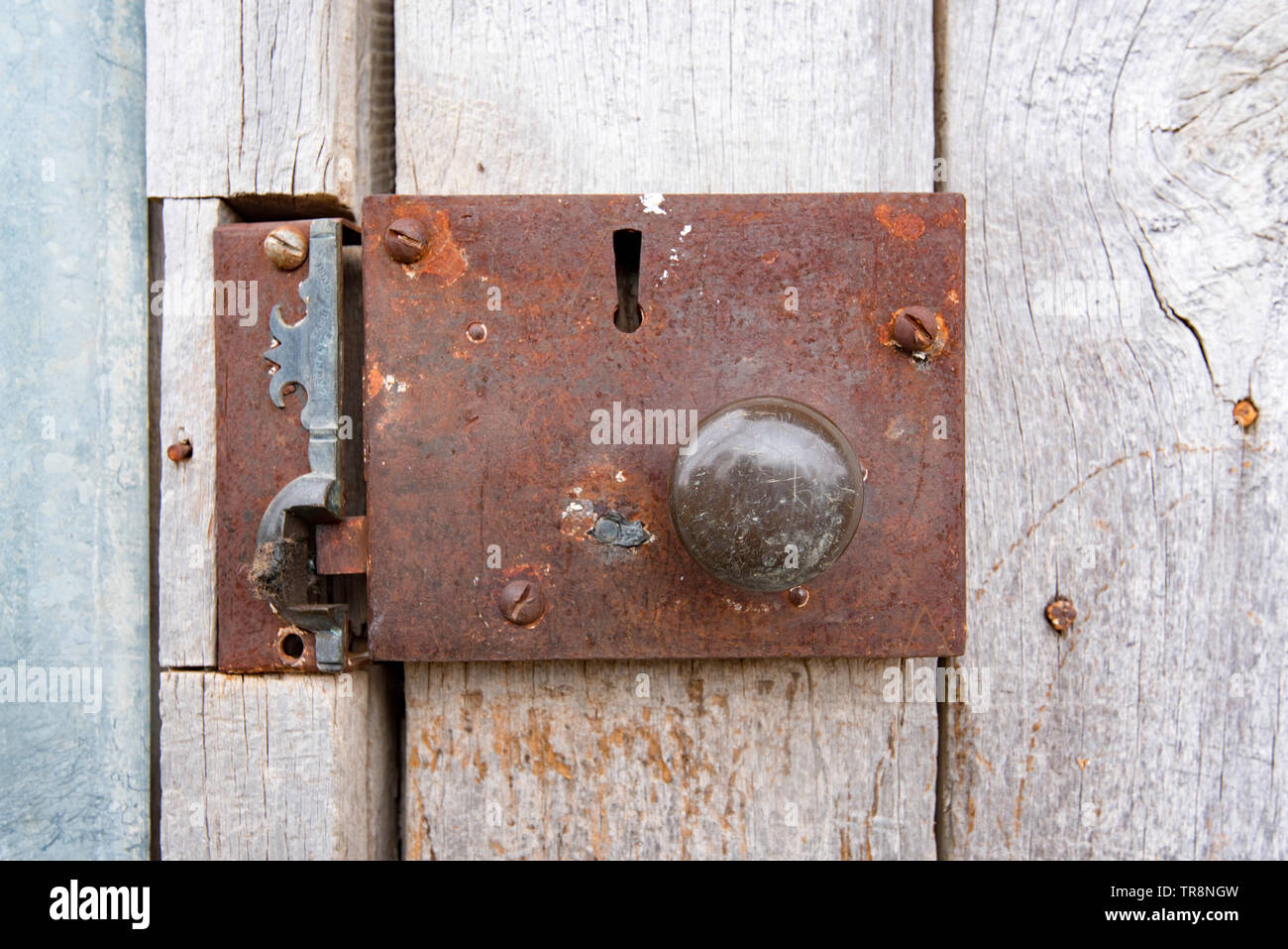 An Old Rusted Door Handle And Lock On The Outside Of A Country