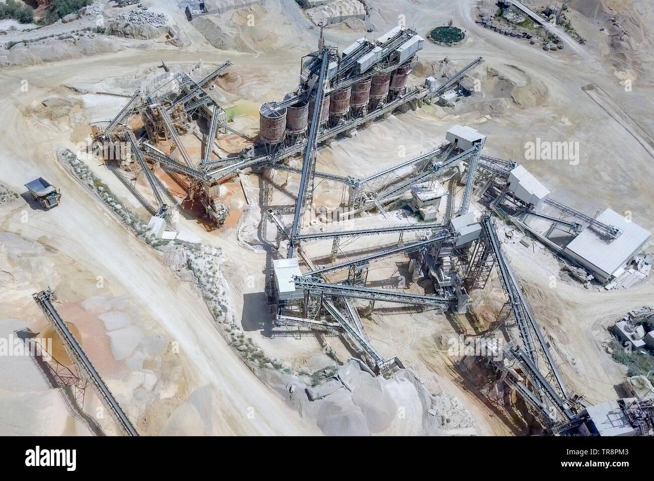 Large Quarry during work hours with Stone sorting conveyor belts - Aerial tour. Stock Photo