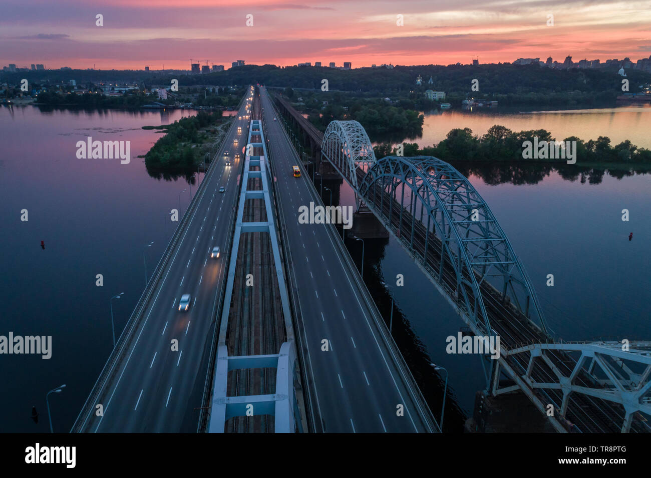 Sunset aerial view on a Darnitsky Bridge, big vehicle and railroad transportation way in Kyiv, Ukraine Stock Photo