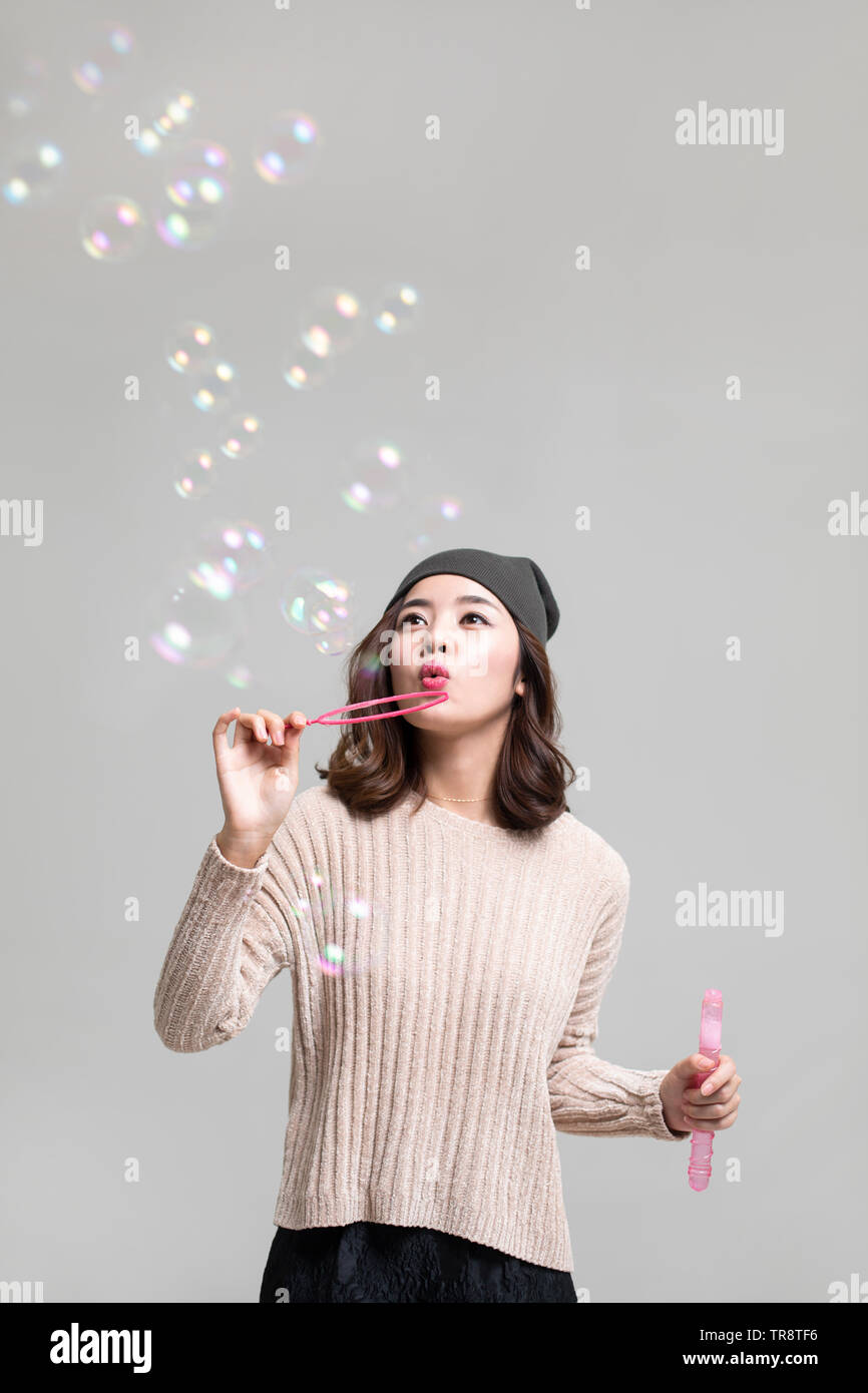 Young woman blowing bubbles Stock Photo - Alamy