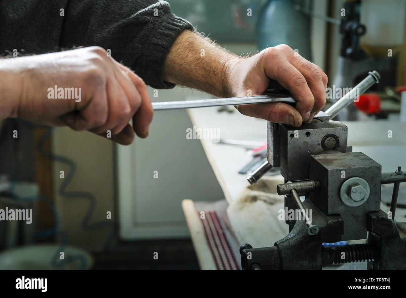 Mechanics repairing a diesel injector. Man's hand holding a wrench and untwists detail pinched