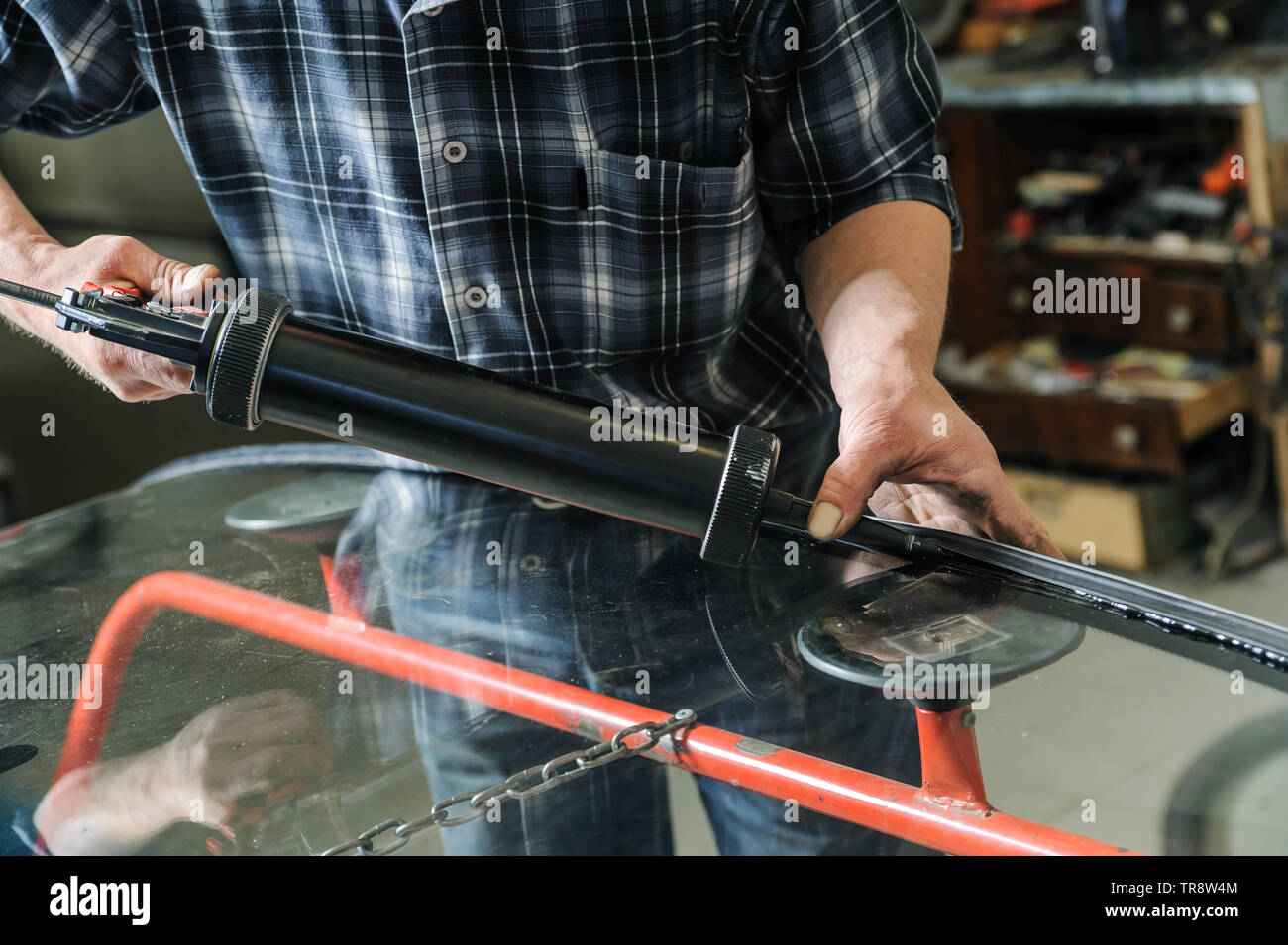 Repair and replacement of the windshield. Car mechanic is putting a