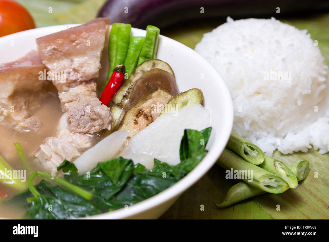 Philippine traditional dish: Sinagang pork soup with vegetables and rice Stock Photo