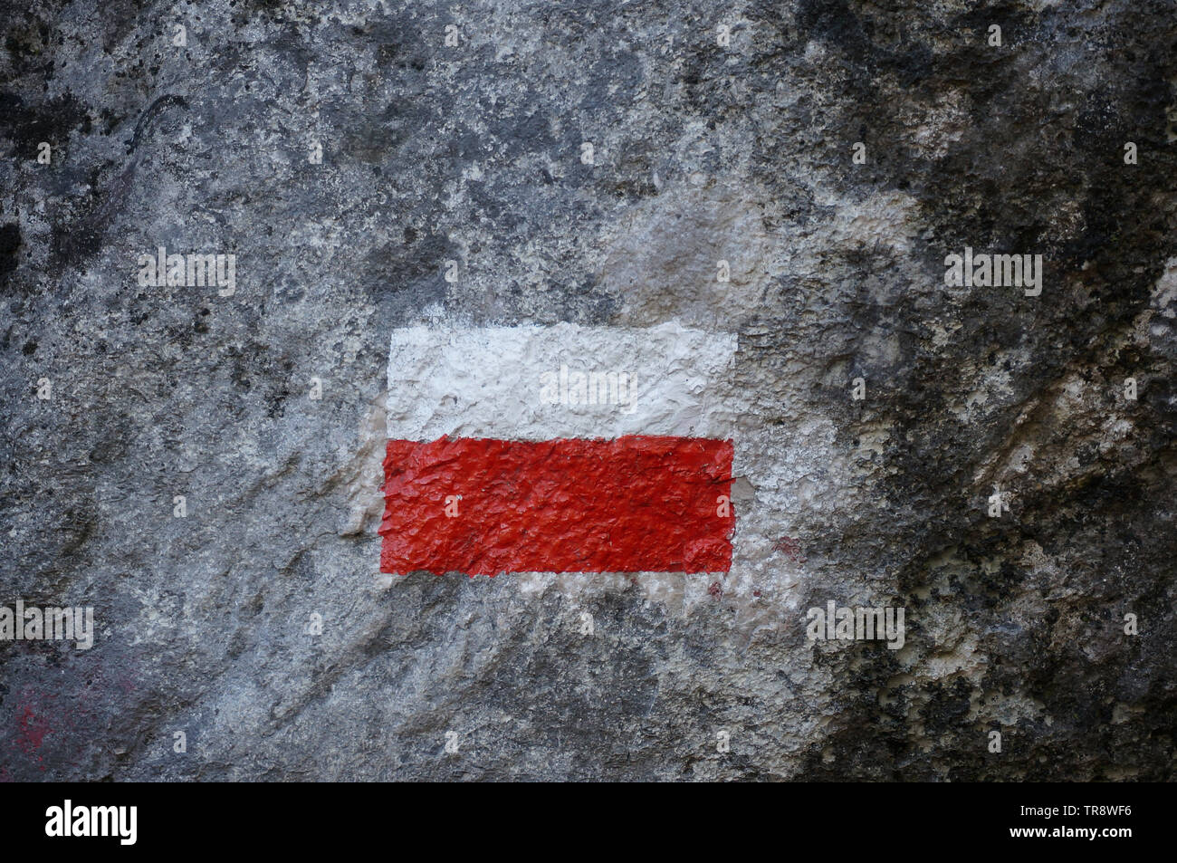 Topographic sign of walking distance painted on rock looking like polish flag Stock Photo